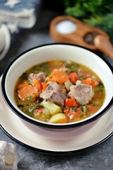 Thick soup with beef, potatoes, tomatoes and bell peppers.