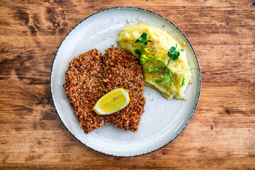 Traditional chicken cutlet in breadcrumbs on white plate