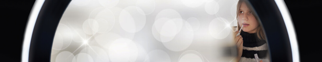 Obraz premium Young woman making photo or video content for social media light of ring lamp. Influencer makes broadcast communicates with followers. Background with copy space. Creative flat lay photo.