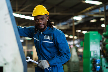 African American industrial experts stand in metal manufacturing factories with a smile.