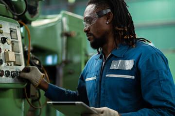 Portrait American male worker working with industrial machines in heavy industry. American engineer working on steel machine.