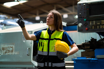 Female industrial maintenance engineers wearing safety uniforms. Inspection and production processes in metal manufacturing factories. Industrial concept manufacturing factories