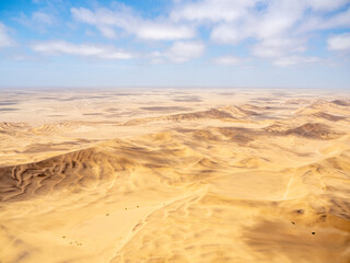 Fototapeta na wymiar Aerial view of Namib Desert as it meets the Atlantic Ocean along the Skeleton Coast of Namibia.