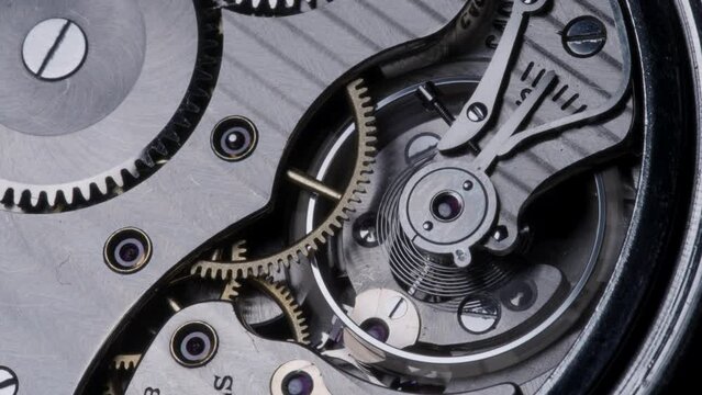 Closeup of a mechanical pocket watch balance wheel and gears - 4K