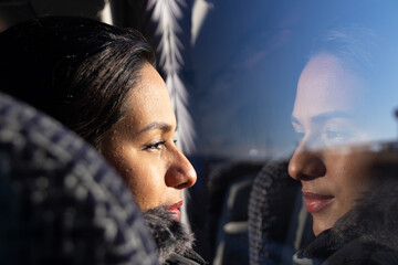 Woman looking out the window of a bus