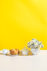 Fototapeta na wymiar Summer still life with breakfast table . Summer background with croissants and daisies. text space 