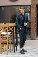 Fototapeta premium Young Businessman standing in outside coffee shop