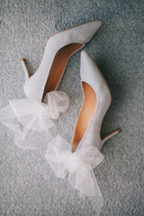 Delicate beautiful shoes of the bride with airy bows