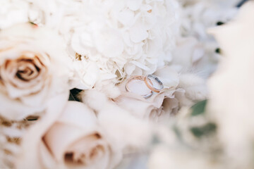 Wedding rings on a wedding bouquet. Wedding day details.