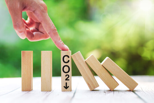 CO2 emission concept. Green industries business concept. Decarbonization of Real Estate. Net zero emissions. ecology solutions. hand stop emitting co2 effect domino stick or reduction of co2 emissions