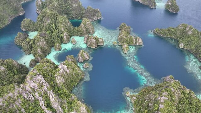Highly eroded limestone islands, surrounded by coral reefs, rise from Raja Ampat's mesmerizing seascape. This remote part of Indonesia is known for its incredibly high marine biodiversity.