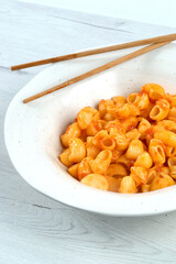 Pasta of snails with tomato on a white plate