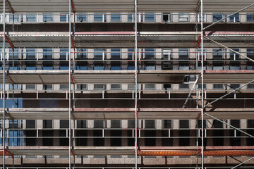 Front exterior view of scaffolding in front of building at construction site.