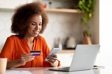 Online Payments. Black woman using smartphone and credit card at home office
