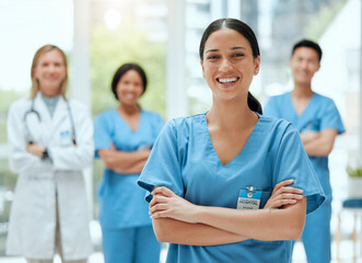 Portrait, medical and a woman nurse arms crossed, standing with her team in the hospital for healthcare. Leadership, medicine and teamwork with a female health professional in a clinic for treatment - obrazy, fototapety, plakaty