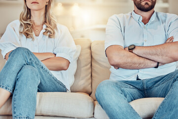 Couple, arms crossed and argument on sofa, home and breakup in divorce, anger and problems. Closeup...