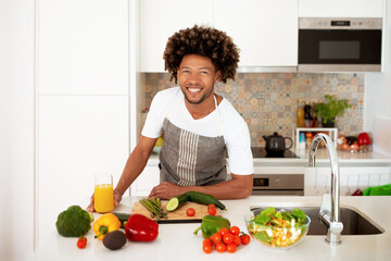 Black Man Posing Near Kitchen Countertop With Fresh Vegetables Indoor