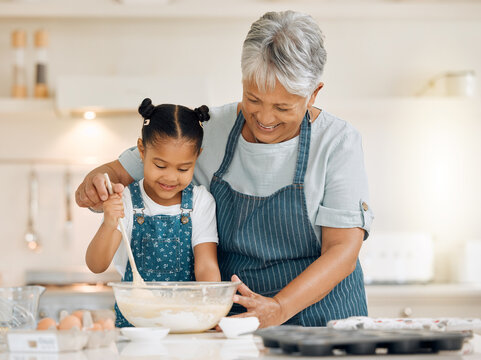 Bake, grandmother and girl with ingredients, learning and development with utensils, food or love. Family, granny or female grandchild in a kitchen, dough or teaching skills with happiness or bonding