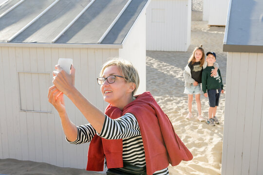 Pick the perfect selfie. Mom chooses lucky angle with children for a selfie