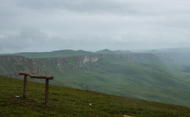 The beauty of nature - dramatic landscape panoramic view of the valley with green hills in a misty haze with soft focus from the Bermamyt plateau in Karachay-Cherkessia