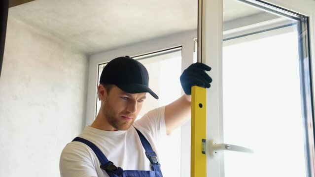 Worker measures of the vertical deviation of pvc windows in apartment