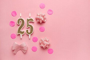 Number 25 on pastel pink background with festive decor. Happy birthday candles. The concept of celebrating a birthday, anniversary, important date, holiday. Copy space. Banner