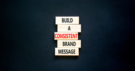 Consistent brand message symbol. Concept words build a consistent brand message on wooden blocks. Beautiful black table black background. Business consistent brand message concept. Copy space.