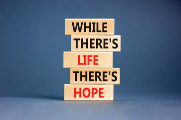 Life and hope symbol. Concept word While there is life there is hope on wooden block. Beautiful grey table grey background. Business lifestyle life and hope concept. Copy space.