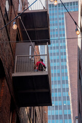man on balcony beneath shadow of sky scraper
