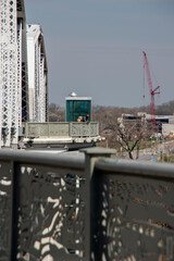 man stops and thinks on the side of a bridge