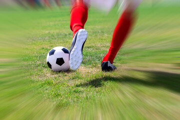 Fußballer mit roten Stutzen schießt einen Ball (Symbolbild)