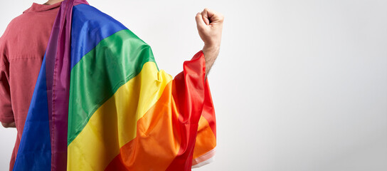 Queer power and lgbt rights concept. Lgbtq+ person with rainbow flag over flexing strong arm