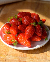Plate with french red ripe sweet strawberries Fraises de Plougastel, harvested in France