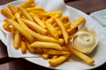 Eating of street or take away food fresh baked french fried potatoes chips with Belgian mayonnaise