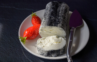 French fresh goat cheese bouche with black mold served with fresh red strawberry, France