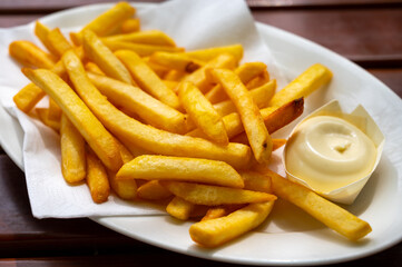 Eating of street or take away food fresh baked french fried potatoes chips with Belgian mayonnaise