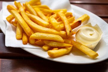 Eating of street or take away food fresh baked french fried potatoes chips with Belgian mayonnaise