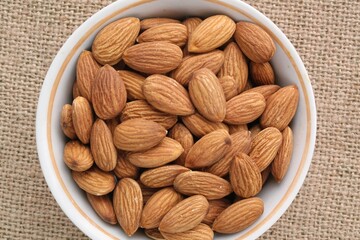 Almond on eco canvas napkin background. Healthy eating diet, nutrition, vegan concept. Protein organic food. Dry snack. National nut day. Copy space for text