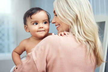 Happy, love and mother bonding with her baby in the nursery room of their modern family home. Happiness, smile and young woman holding a cute girl infant child with care and affection in their house.