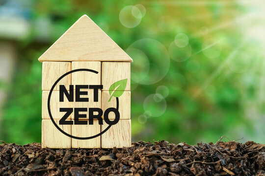 CO2 emission concept. Green industries business concept. Decarbonization of Real Estate. Net zero emissions. ecology solutions. House shaped wooden cube with net zero icon on nature background.  