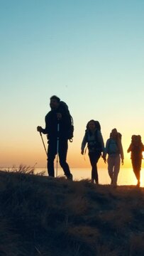 The four travelers walking on the mountain top near the sea. slow motion
