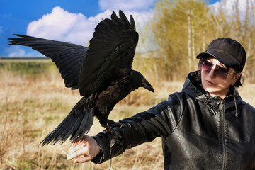 Young woman posing with a raven...