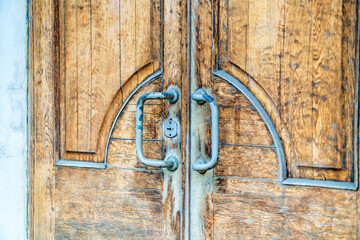 Old wooden doors covered with varnish with shabby handles
