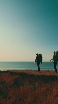The two people walking on the mountain on the sunset background