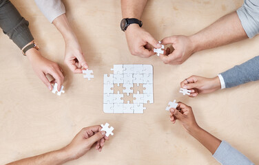 Puzzle, hands and office group with planning and problem solving at a table. Above, teamwork and...