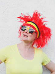 Portrait of a caucasian blonde woman with a Belgian flag wig with red hair and sunglasses