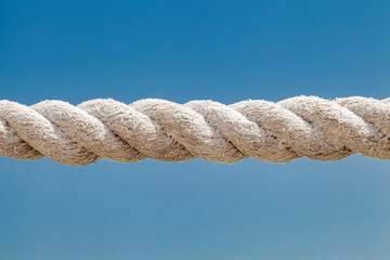 Part of rope of old weathered close-up against the blue sky