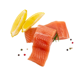 A raw piece of red fish fillet (trout, salmon) with a slice of lemon isolated on transparent background pngd. seafood with pepper mix 