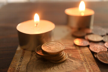 burning candle with coins. South African currency the Rand. Concept of rising energy costs....