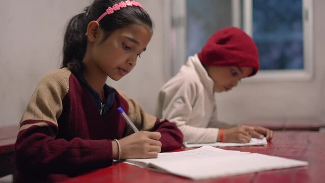Indian children studying and taking notes in the classroom at elementary school, learning and education concept. 